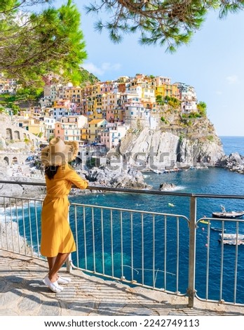 Asian women with a hat visiting Manarola Village Cinque Terre Coast Italy during summer on a sunny day at the Ligurian coast