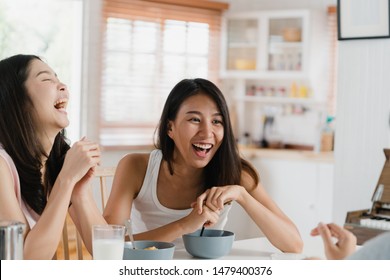 Asian women have breakfast at home, Group of young Asia friend girls feeling happy fun talking together while have breakfast in kitchen in the morning concept.
