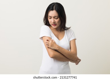 Asian women have skin problems She felt irritation on her skin. Skin infection itching red rash scratching with hands. She around 25 Wearing white shirt standing on isolate background