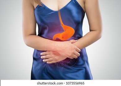 Asian women have a stomach ache because of stomach ulcers against gray background, Stomach pain, Esophageal ulcer, Concept with body problem - Shutterstock ID 1073556965