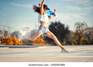 Asian Women Hold Surf Skate Or Skateboard Outdoors And Jumping On Beautiful Summer Day.