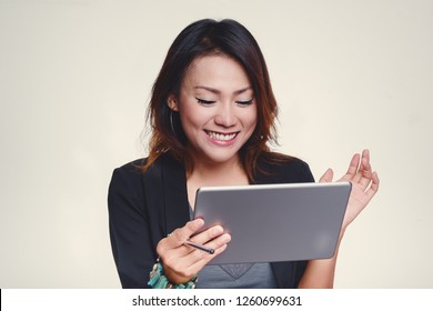 Asian Women Look At His IPad With A Happy Mood.Focus On The Face.