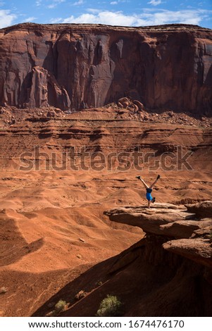 An asian women making a handstand in the monument valley
