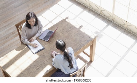 Asian Women Meeting While Looking At A Computer