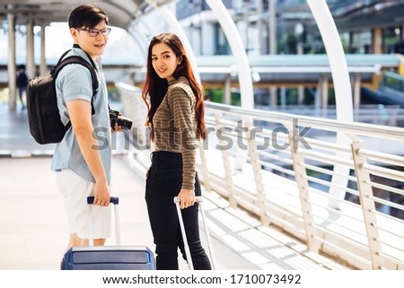 Asian women and men dress in a special dress and carry a backpack and drag the luggage. They are going to go to the airport to go after the government cancel the lockdown.