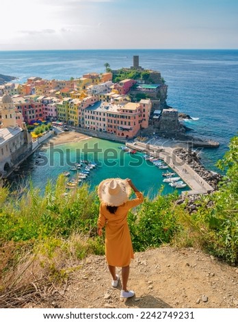 Asian women on a hill at the ocean looking out over Vernazza village Cinque Terre Italy, The picturesque coastal village of Vernazza, Cinque Terre, Italy. 
