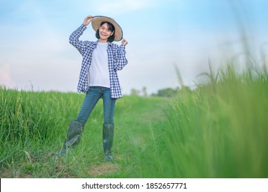 Asian women pose and smile at the green farms. full body portrait image