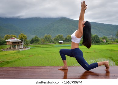 Asian Women Are Practicing Yoga To Become Physically Fit And Happy. In The Accommodation This View Is A Field.