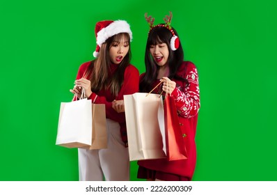 Asian women in red christmas theme costume carrying and open shopping bag green screen background.  - Powered by Shutterstock