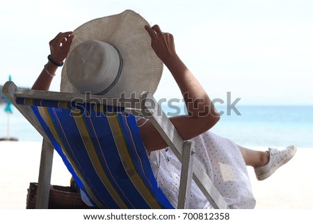 Asian women relax and have a good time when she sitting on color canvas chair  in a good day at the beautiful beach