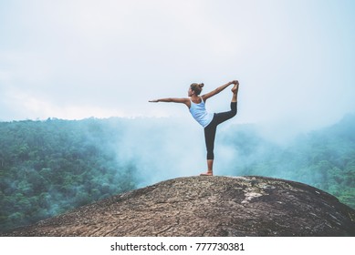 Asian Women Relax In The Holiday. Play If Yoga. On The Moutain Rock Cliff. Nature Of Mountain Forests In Thailand