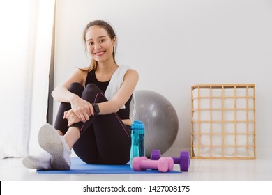 Asian women resting after play yoga and exercise at home background with copy space.Exercise for Lose weight, increase flexibility And tighten the shape.