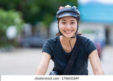 Asian women ride bicycles to work.