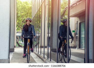 Asian Women Riding Bicycles Put Safety Helmet Go To University.