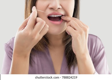 Asian Women In Satin Robes Cleaning Her Teeth Against Gray Background, Woman Flossing Teeth With Dental Floss, Oral Hygiene And Health Care - Powered by Shutterstock