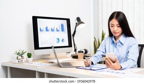 Asian Women Sit At Their Desks And Calculate Financial Graphs Showing Results About Their Investments, Plan A Successful Business Growth Process.