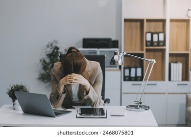 Asian women sitting in an office With stress and eye strain Tired, portrait of sad unhappy tired frustrated disappointed lady suffering from migraine sitting at the table, Sick worker concept - Powered by Shutterstock