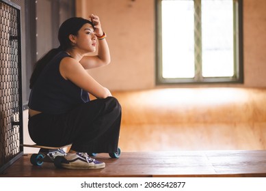 Asian women skater doing tricks jumping in the underground garage. Urban activity indoor lifestyle. - Powered by Shutterstock