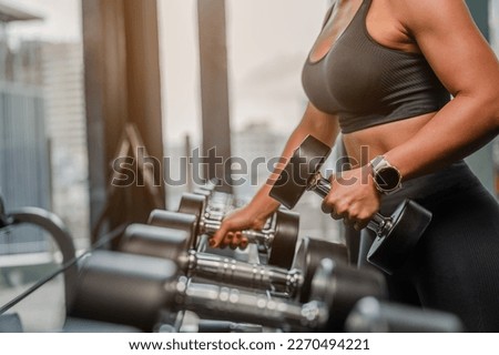 Asian Women in sportswear working out with weights over exercise bench exercising are lifting dumbbells at fitness gym in the morning.Fitness muscular body.Fitness, gym, workout and healthy concepts. 