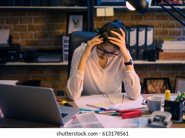 Asian women are stressed out of work. She is in the office at night