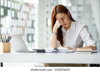 Asian women are stressed while working on laptop, Tired asian businesswoman with headache at office, feeling sick at work, copy space