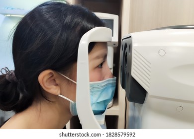 Asian Women With Surgical Mask And Optometrist Examining Eyesight Patient In Optician Office