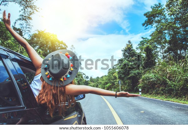 Asian women\
travel relax in the holiday. Traveling by car park. happily With\
nature, rural forest. In the\
summer