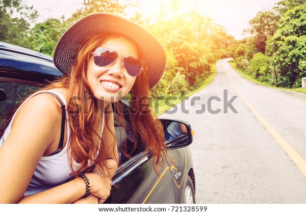 Asian women travel relax in the\
holiday. Traveling by car park. happily With nature, rural\
forest