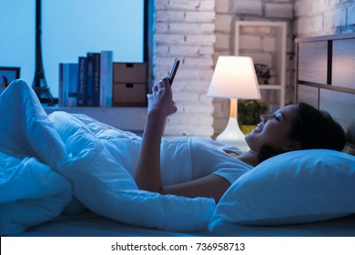 Asian women are using the smart phone on the bed before she sleeping at night. Mobile addict concept. - Powered by Shutterstock