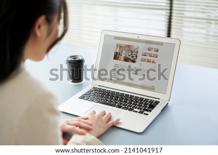 Asian women viewing real estate websites on a computer