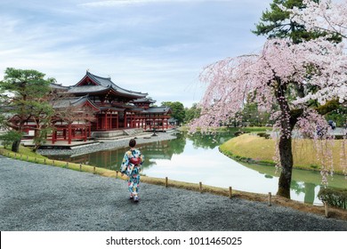 Asian women wearing traditional japanese kimono in Byodo-in Temple in Uji, Kyoto, Japan during spring. Cherry blossom in Kyoto, Japan.
