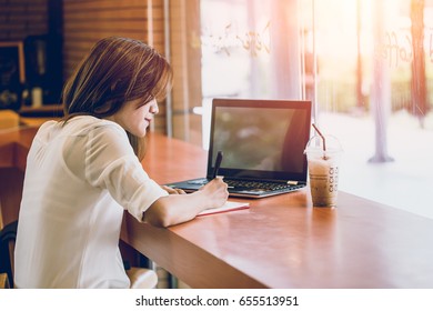 asian women woking at the cafe with laptop and writing note. thinking business project action. - Shutterstock ID 655513951