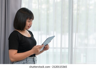 Asian Women Working On Laptop At Room. Concept Of Work Form Home. Portrait Women Smile Use Technology Mobile. Concept Business.