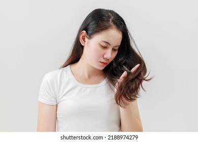 Asian women are worried about their damaged hair causing a lack of confidence. Hair loss treatment concept, damaged hair, beauty salon.