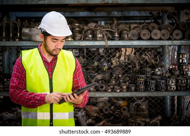 Asian Worker Using Tablet For Work In Factory Warehouse Car Parts.