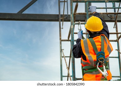 Asian worker wear safety height equipment. Fall arrestor device for worker with hooks for safety body harness, Worker as in the construction site