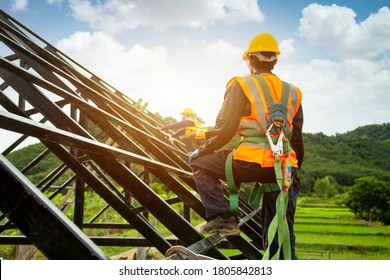 Asian worker wear safety height equipment to install the roof. Fall arrestor device for worker with hooks for safety body harness, Worker as in the construction site