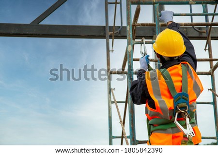 Asian worker wear safety height equipment. Fall arrestor device for worker with hooks for safety body harness, Worker as in the construction site