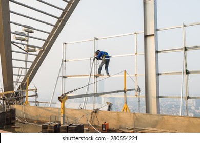 Asian worker weld on top of high building without scaffolding, low safety working condition 