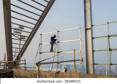 Asian worker weld on top of high building without scaffolding, low safety working condition 