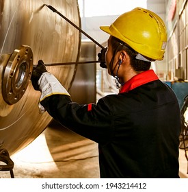 Asian workers are using compasses to mark steel plates