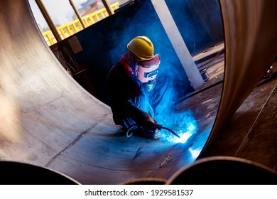 Asian workers welding metal steel plates in the factory