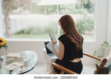 Asian working woman hold mobile phone text message, chat conversation or using social media. Businesswoman use smartphone browse web, read e-book, trade stocks. Communication technology concept.