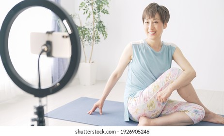 Asian yoga instructor distributing online yoga classes. - Powered by Shutterstock