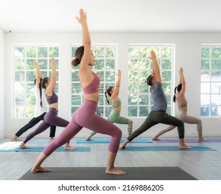 Asian yoga trainer and her student pose yoga basic position in her class room in fitness center - Powered by Shutterstock