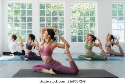 Asian yoga trainer and her student pose yoga basic position in her class room in fitness center - Powered by Shutterstock