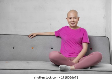 Asian Young Adult Female Cancer Patient Relaxing On A Couch, Smiling.