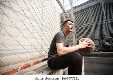 Asian Young Adult Man Basketball Player Sitting Resting At Courtside