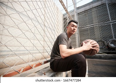 Asian Young Adult Man Basketball Player Sitting Resting At Courtside