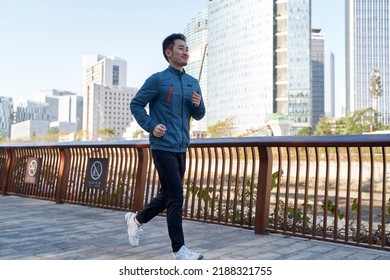 Asian Young Adult Man Running Jogging Exercising In City Park